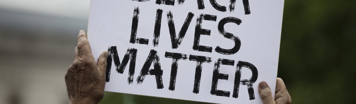 Ein BlackLivesMatter Plakat, das bei einer Demo hochgehalten wird.