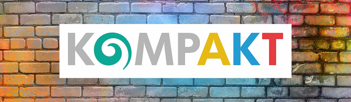 Bunte Backsteinmauer mit KompAKT Logo